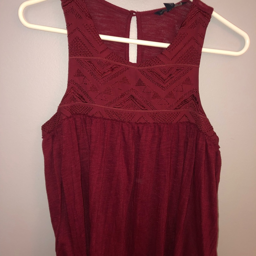 Maroon tank top with detailing at the top.
